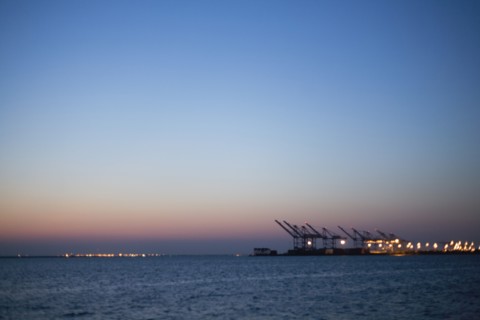 Silhouette of cranes in dock at dusk
