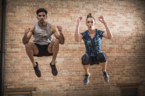 Man and woman jumping in gym