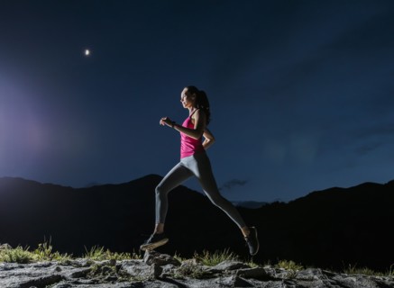 Woman jogging in mountains at night