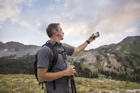 Male hiker photographing mountain landscape