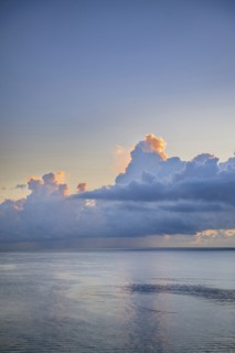 Large cumulus clouds over an early morning ocean
