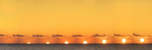 Sequential sun rising above calm ocean