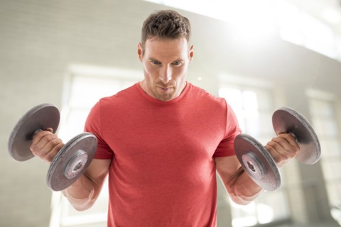 Man exercising with dumbbells in gym