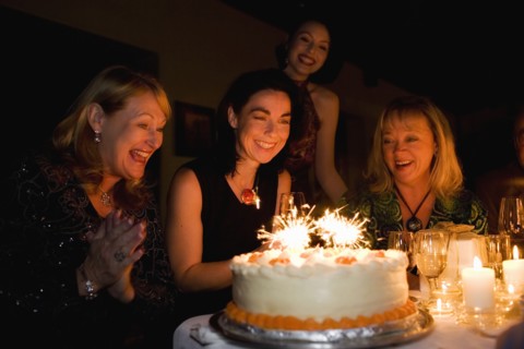 Group of friends celebrating birthday in restaurant
