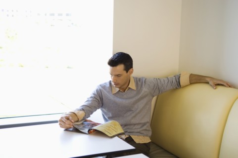 Businessman reading magazine in cafeteria