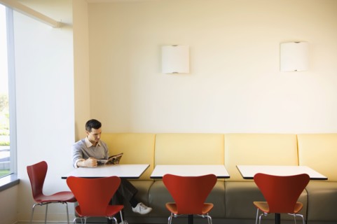 Businessman reading magazine in cafeteria