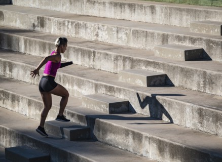 Woman with amputated hand jogging up steps