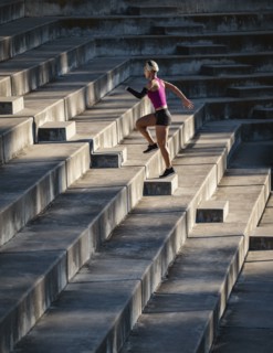 Athletic woman with amputated hand running up steps