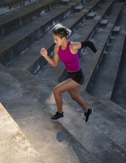 Athletic woman with amputated hand running up steps