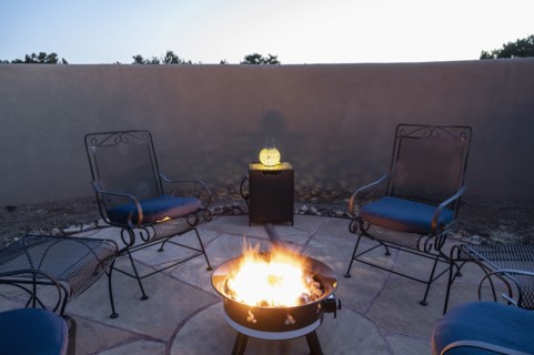 Chairs around back yard fire pit at dusk