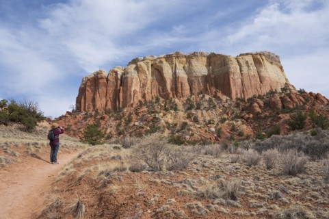 Rear view of female hiker photographing mesa in desert landscape