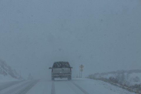 Pick-up truck on snow covered highway 20 in rural landscape