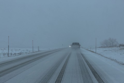 Pick-up truck on snow covered highway 20 in rural landscape