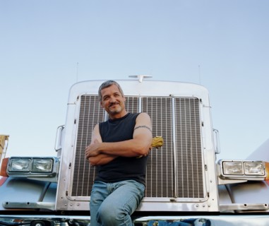 Truck driver leaning on his vehicle