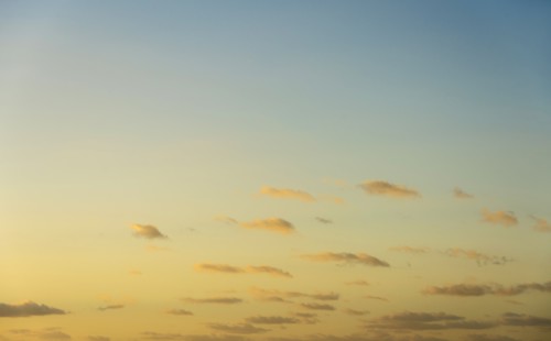 Blue sky with small calm clouds at sunrise