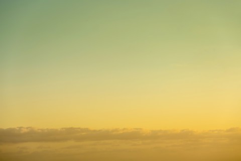 Golden sky at sunrise with low clouds below