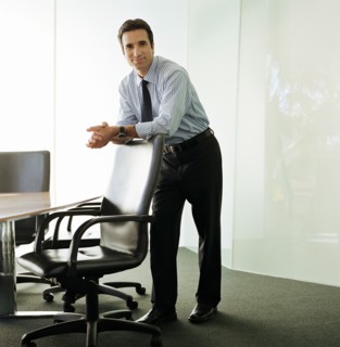 Businessman leaning on chair in boardroom