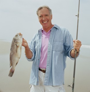 Portrait of smiling fisherman holding catch