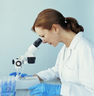 Lab technician looking through microscope