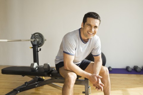 Portrait of man sitting on weight bench
