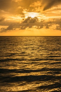 Orange clouds over ocean at sunrise