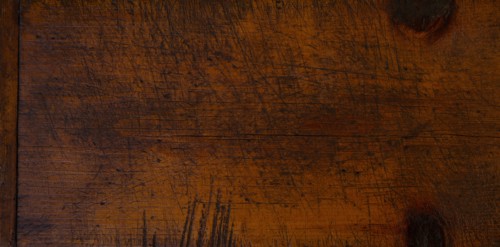 Close-up of worn antique cutting board with knife cut marks