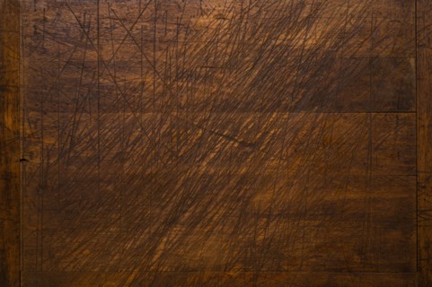 Close-up of worn antique cutting board with knife cut marks