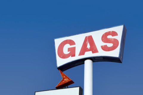Low angle view of vintage gas station sign against sky