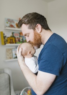 Father kissing newborn son