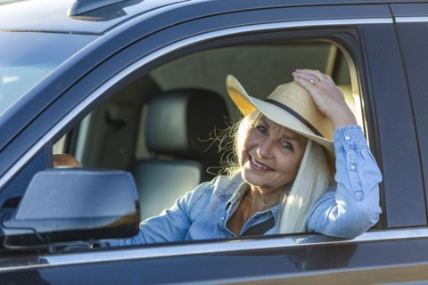 Blonde woman in car wearing cowboy hat