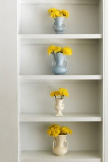 Shelf with vases and yellow flowers