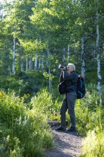 Senior man taking photographs while hiking