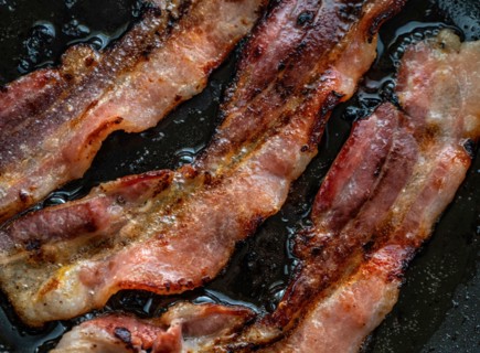 Close-up of bacon slices on frying pan