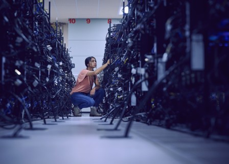 Female technician working in server room