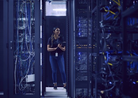 Female technician working in server room