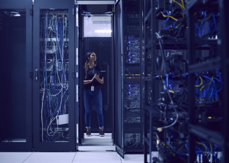 Female technician working in server room