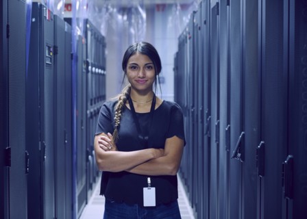 Portrait of smiling female technician standing in server room