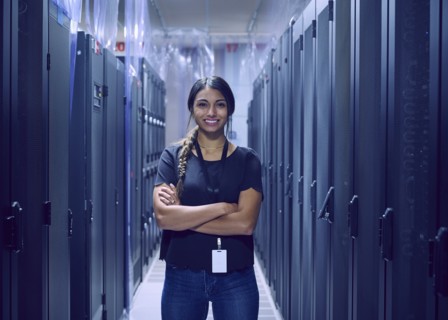 Portrait of smiling female technician standing in server room