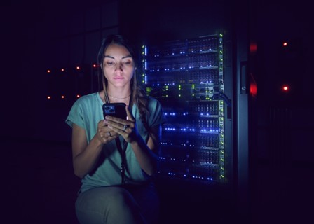 Technician using smart phone in server room