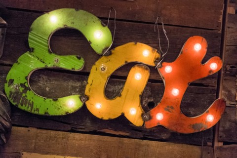 Old illuminated restaurant sign on wooden surface