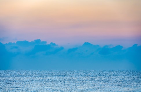 Clouds above calm ocean at sunrise
