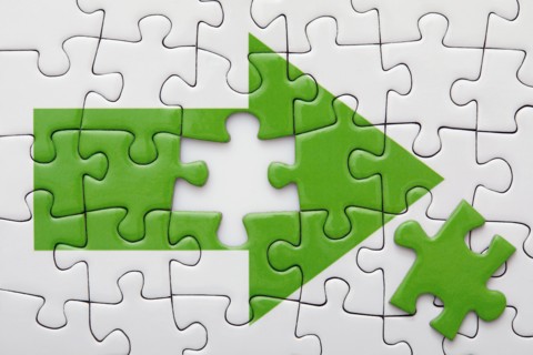 Jigsaw puzzle with green arrow