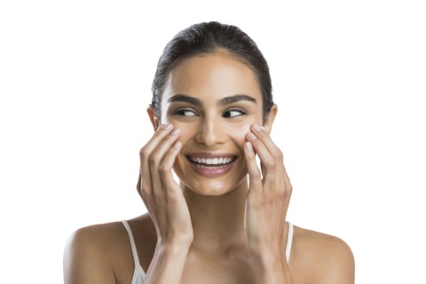 Portrait of young woman doing face massage