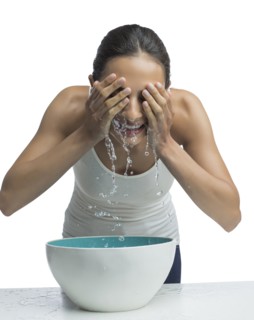 Portrait of young woman washing face