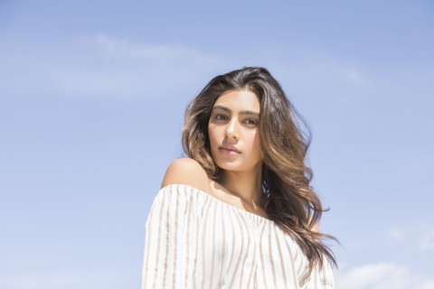 Portrait of serious young woman against clear sky