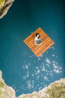 Aerial view of woman sitting on wooden raft
