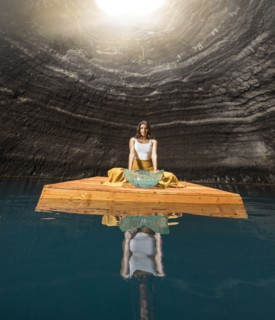 Woman sitting on wooden raft in cenote