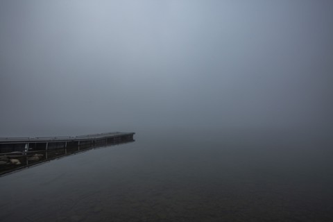 Wooden jetty at edge of mountain lake