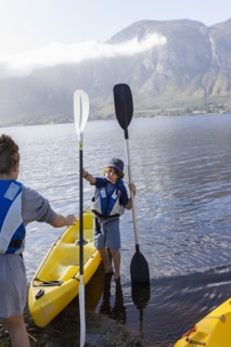 Boy and teenage girl preparing for kayaking