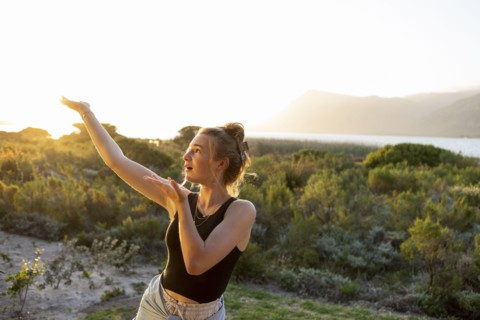 Teenage girl dancing at sunset